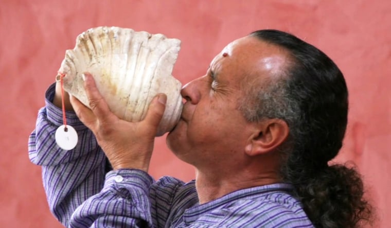 A researcher sounds a note on a conch-shell trumpet as part of an experiment to re-create the ceremonial calls heard by ancient Andeans in the Chavin de Huantar ceremonial center in Peru.