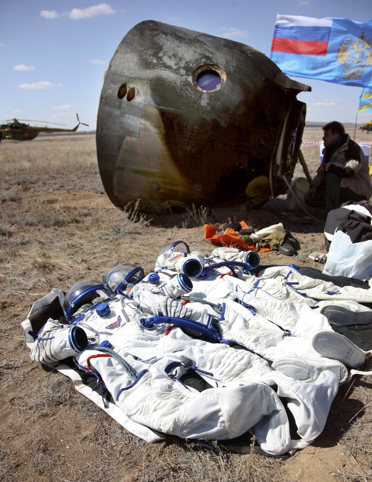 Spacesuits lie next to the Soyuz space capsule that returned from the International Space Station to the Kazakh steppes on April 8, 2009. The capsule, as well as Charles Simonyi's spacesuit, will go on display at Seattle's Museum of Flight.