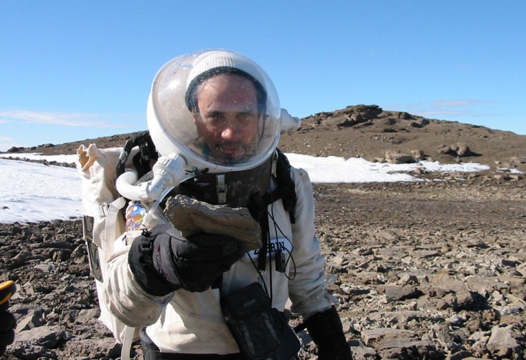 The Mars Society's Robert Zubrin holds out a fossil found during a Mars mission simulation conducted on Devon Island in the Canadian Arctic in 2001.