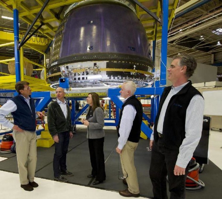 NASA Deputy Administrator Lori Garver meets Jeff Bezos, the billionaire founder of the Blue Origin, and other team members next to the prototype space capsule at the space venture's headquarters and production facility in Kent, Wash., on Thursday. From left are Jeff Ashby, Bezos, Garver, Rob Meyerson and Robert Millman. Blue Origin is one of several companies receiving NASA funds for the development of next-generation spaceships.