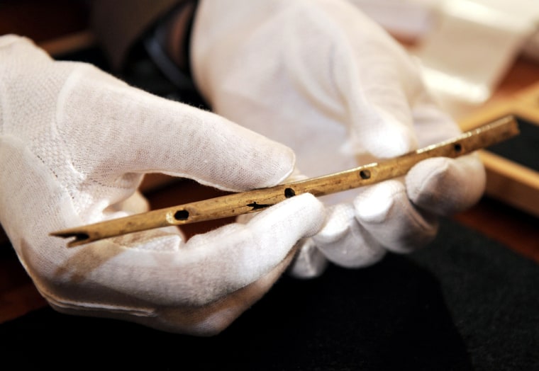 This 35,000-year-old bird-bone flute, held by the University of Tübingen's Nicholas Conard, is considered one of the world's oldest handcrafted musical instruments. But researchers say human musicmaking has much more ancient roots.