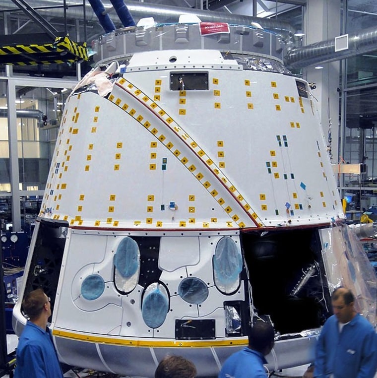 Technicians prepare SpaceX's Dragon capsule for thermal vacuum chamber testing in a clean room at the company's production facility in Hawthorne, Calif.