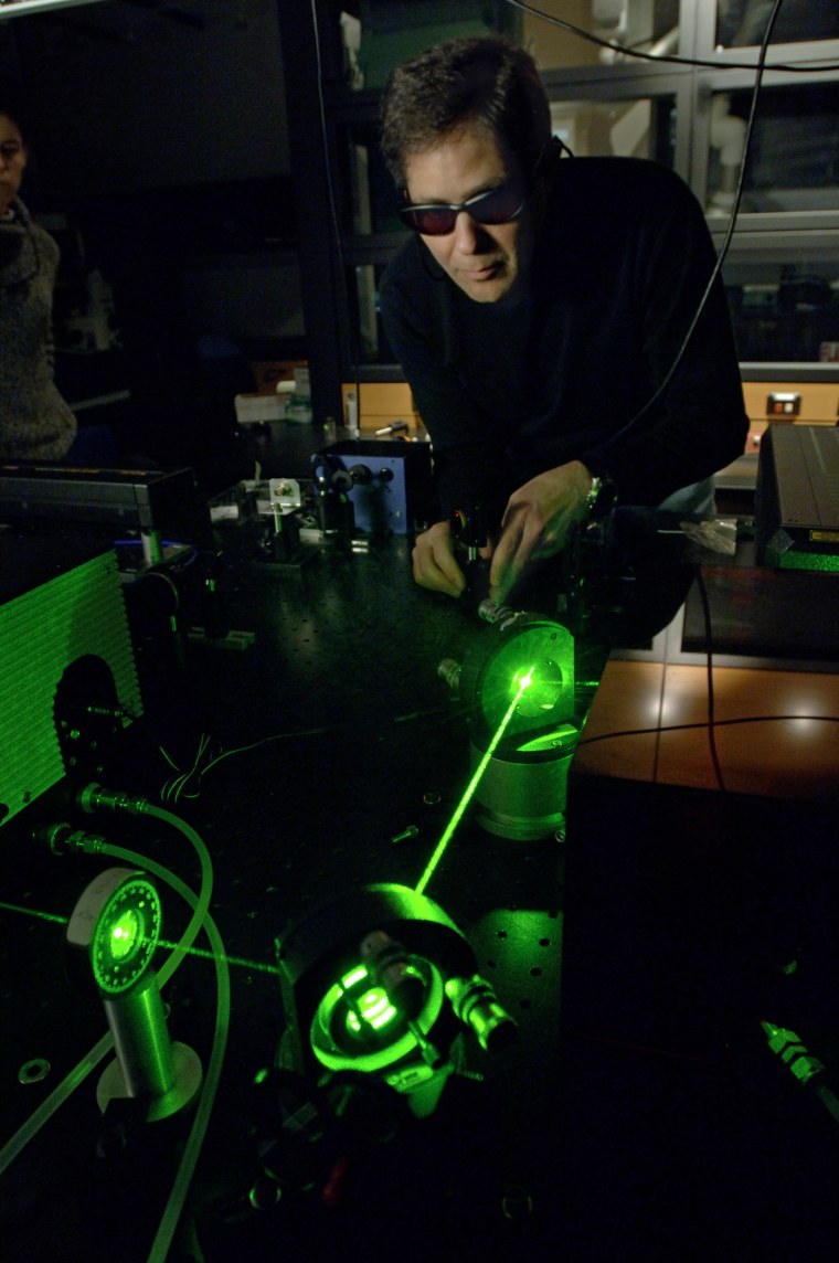 Michigan State University professor Marcos Dantus works with an associate in his laboratory in the Chemistry building.