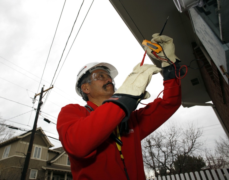 In this file photo Gary Kawano installs a new meter outside a home in Boulder, Colo., as part of the smart electrical grid system being put into place in the university city.