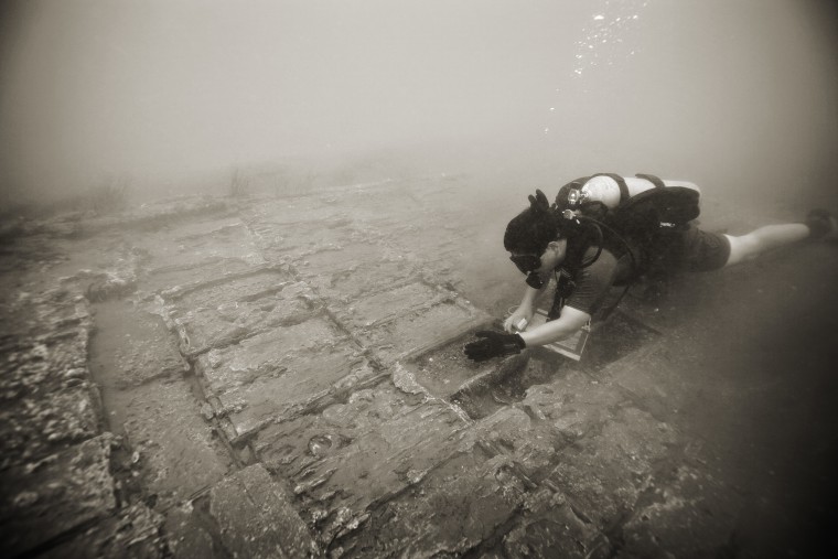 Bert Ho, an underwater project survey archaeologist with the National Park Service's Submerged Resources Center, based in Denver, maps the shipwreck with drawings using synthetic calque paper and plastic lead pencils.