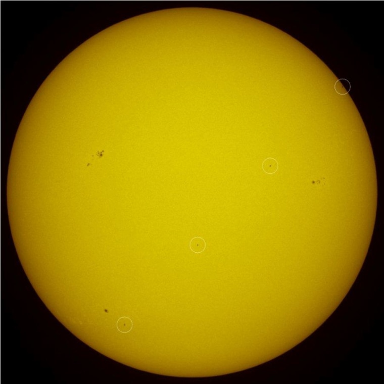 A four-image composite tracks Atlantis' transit across the sun's disk, just 21 minutes before today's deorbit burn. The white circles highlight Atlantis.