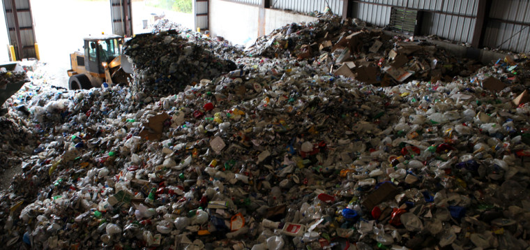 A front loader pushes around tons of collected material at the Ocean County Recycling Center in New Jersy. A new machine can convert plastic waste into fuel, which could prevent it from going into landfills.