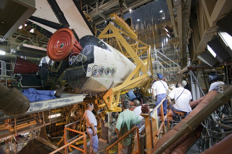 Technicians work on the space shuttle Discovery inside Orbiter Processing Facility 3 at NASA's Kennedy Space Center in Florida, in preparation for a flight that is due for launch this fall. Discovery's flight is the next shuttle mission on NASA's schedule.