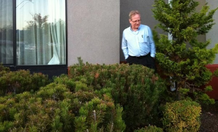 Msnbc.com's Alan Boyle walks through the bushes outside an Oregon hotel, looking for a place to plug in the Chevy Volt.