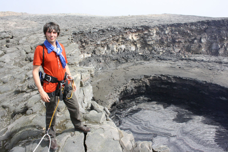 British physicist Brian Cox, host of the "Wonders of the Solar System" documentary series, is hooked up with safety harnesses as he stands on the edge of the Erta Ale volcano in Ethiopia. Erta Ale's lava lakes are considered an earthly analog to Io, a moon of Jupiter that is the most volcanically active world in the solar system.