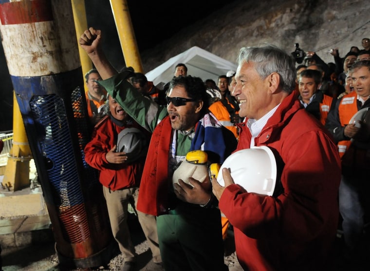 Chilean President Sebastian Pinera speaks with the last miner to be rescued, Luis Urzua, with the Phoenix rescue capsule in the background. NASA helped with the capsule's design and would love to hear from the Chileans how it worked out.