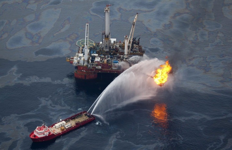 A ship sprays water on a burner that disposes of oil and natural gas brought up from a leaking well in the Gulf of Mexico.