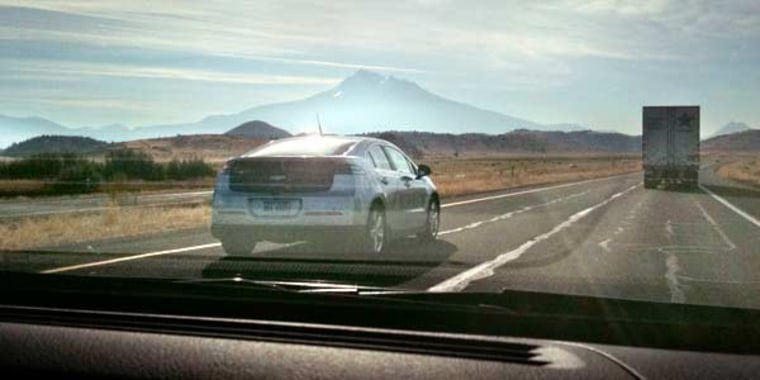 A Chevy Volt tools down Interstate 5 with Mount Shasta in the background, as seen through the windshield of another Volt.