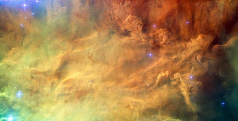 A close-up shot of the Lagoon Nebula's center shows the delicate structures formed when powerful radiation from young stars interacts with the hydrogen cloud from which they sprang. The color-coded image was created from exposures taken with the Hubble Space Telescope's Advanced Camera for Surveys. Light from glowing hydrogen is colored red, light from ionized nitrogen is green, and light through a yellow filter is colored blue.