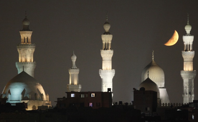 The moon looms over the mosques of old Cairo on Aug. 15 during the holy month of Ramadan.