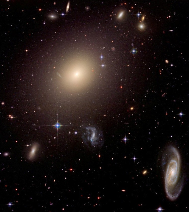 A Hubble Space Telescope picture of the Abell Cluster reveals a wide range of galactic diversity. A giant elliptical galaxy dominates the center of the image, but there's also a beautiful spiral at lower right and many smaller galaxies.