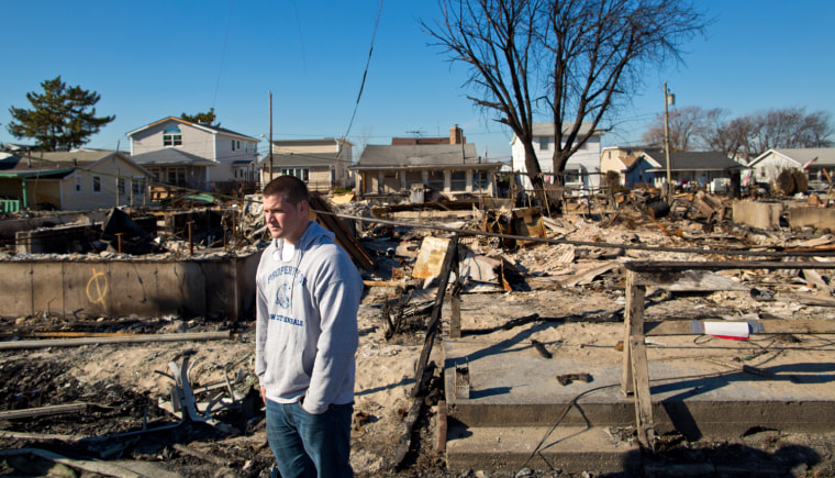 Standing in front of what remains of his aunt's house, Matt Petronis takes in the burned section of Breezy Point, N.Y., where more than 100 homes were destroyed by fire at the height of Hurricane Sandy on Oct. 29. It was his first day back in his hometown from college since the storm.