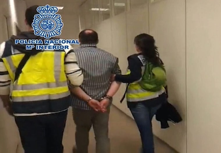 Two Spanish police officers detain Liberty Reserve founder Arthur Budovsky at Barajas airport in Madrid, Spain on Tuesday. Budovsky is being held as part of money-laundering investigation involving the United States.