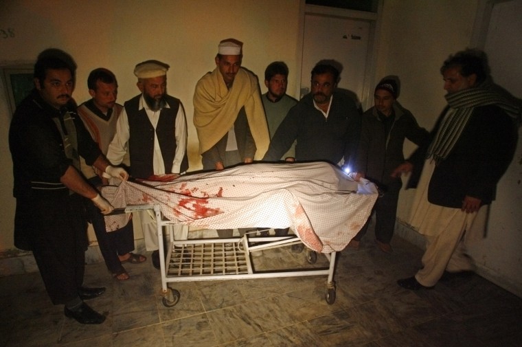 People surround the body of an aid worker, who was killed by unidentified gunmen, at a hospital in Swabi, Pakistan, on Jan. 1, 2013, after gunmen ambushed and shot dead six Pakistani women aid workers and a male doctor. Their driver was seriously wounded in the attack.