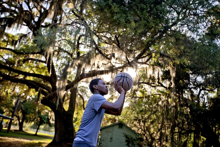 Marvin Grovner, 16, plays with a basketball after returning home to the Hog Hammock community of Sapelo Island, Ga. from school on the mainland on May 15.