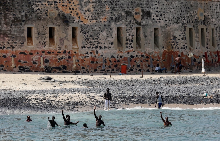 Youths swimming in front of a colonial-era fort on Senegal's Goree Island wave to an arriving ferry in October, 2012. President Barack Obama will visit the Maison des eclaves (House of Slaves) on the island when he visits.