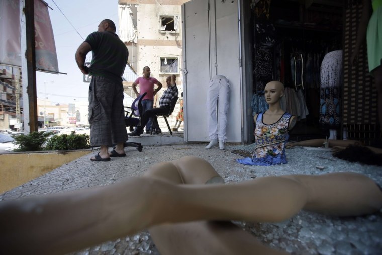 Residents inspect their damaged shops near the Bilal bin Rabah mosque in the Abra district of Sidon on June 25.