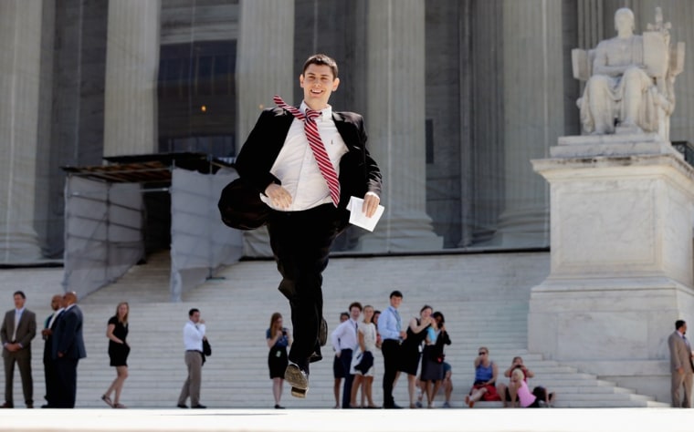 A news assistant runs after a ruling was made outside the U.S. Supreme Court building on June 25, in Washington, D.C. The court ruled that Section 4 of the Voting Rights Act is unconstitutional.