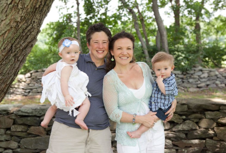 Army Maj. Shannon McLaughlin and her wife, Casey, hold their twins, Grace and Grant