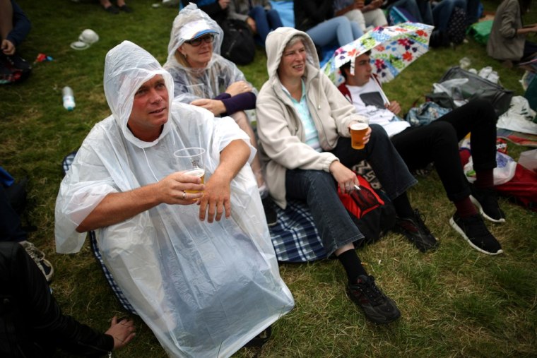 Spectators wait in the rain for play to resume on day four of the Wimbledon Lawn Tennis Championships tennis tournament at the All England Club in Wimbledon, southwest London, on June 27, 2013.