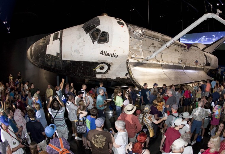 Visitors view the space shuttle Atlantis on the opening day of its exhibit at the Kennedy Space Center Visitor Complex in Cape Canaveral, Florida June...
