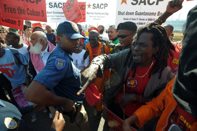 Protestors face police officers during a demonstration against the visit of US President Barak Obama in South Africa on June 29, 2013 in Soweto. US President Barack Obama Saturday decided not to visit his political hero Nelson Mandela in hospital to preserve the