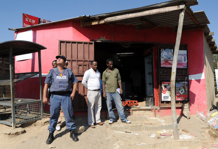 Police stand guard outside a foreign-owned shop in Diepsloot, South Africa, on May 27 after a mob of looters targeted outlets amid simmering anger toward immigrants.