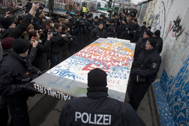 Police carry away a protester's styrofoam copy of a segment of the Berlin Wall at a demonstration against the removal of several segments of the original former Berlin Wall, now known as East Side Gallery, in Berlin on March 1, 2013.