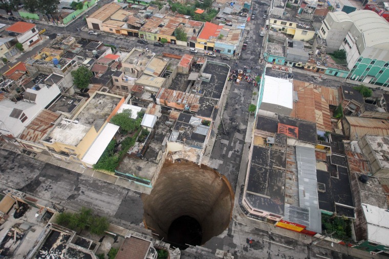 In this file photo released by Guatemala's Presidency, a sinkhole covers a street intersection in downtown Guatemala City, May 31, 2010.