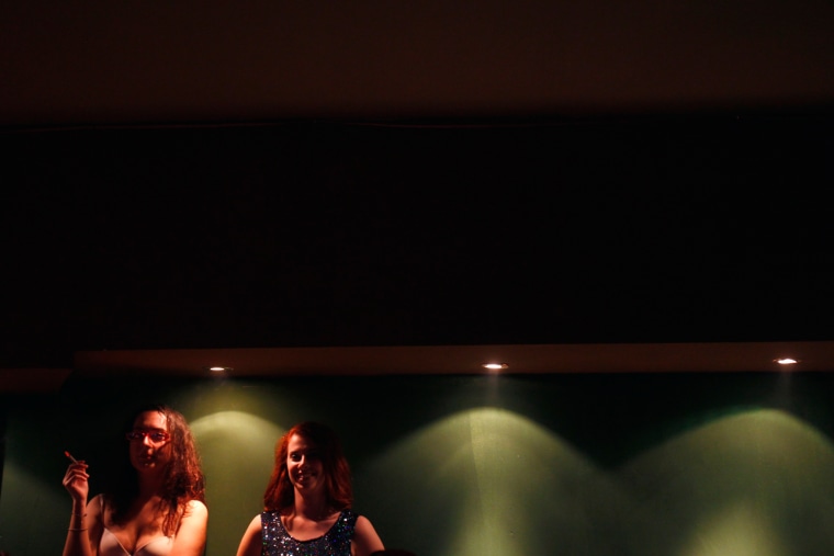 Women watch a male striptease show.