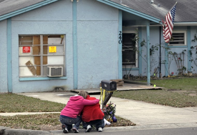 Jeremy Bush, right, is consoled by an unidentified woman Sunday, March 3, 2013, as he sits outside a home where a sinkhole opened up underneath a bedroom late Thursday evening, swallowing his brother, Jeffrey Bush, in Seffner, Fla. Crews on Sunday began the demolition of the Florida home.
