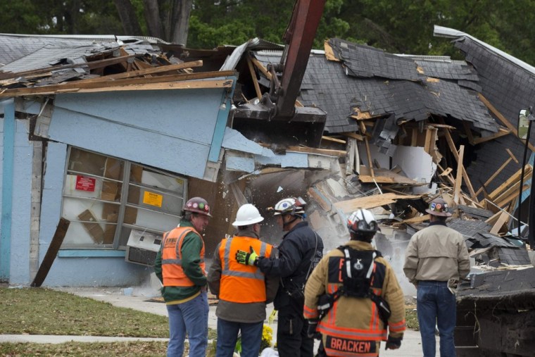 Demolition crews and Hillsborough County Fire Department watch as the house, where Jeffrey Bush was swallowed by a sinkhole, is demolished in Seffner, Florida March 3, 2013.