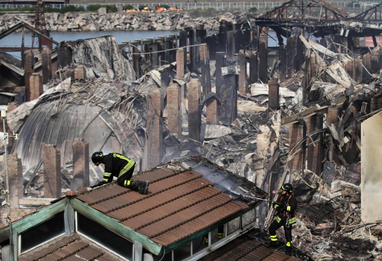 Members of the fire services continue to hose down a smouldering building amid the scene of devastation in Naples on March 5 following the night time blaze that destroyed much of the southern Italian port's City of Science complex. Fire Brigades in action the day after the massive blaze that destroyed much of Naples Città della Scienza