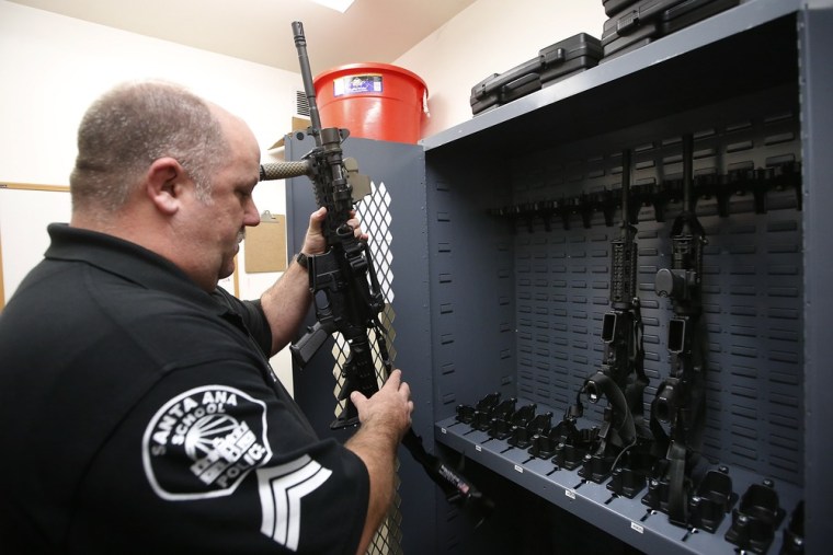 School police Sgt. Kevin Philips checks out a rifle from the police armory in Santa Ana, Calif., on Jan. 24. Officials in this Los Angeles-area city say the high-powered weapons now in the hands of school police could prevent a massacre.