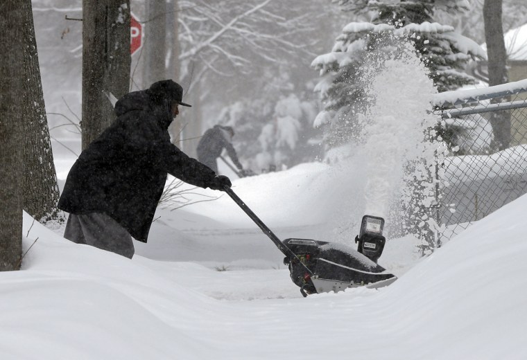 Two men clear snow on March 5, in Minneapolis as a winter storm dumped snow on much of the state. Tens of thousands of Minnesota students got a day off Tuesday as the second day of a slow-moving snowstorm made travel difficult across much of the region.