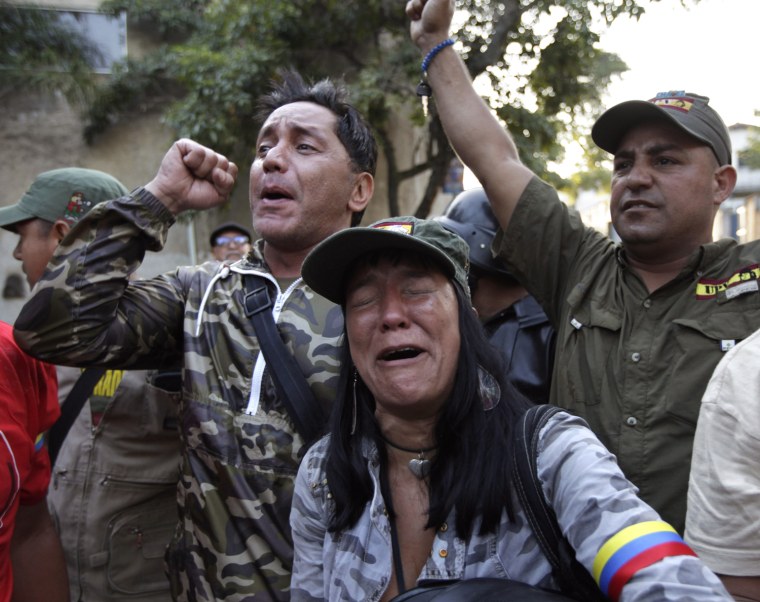 Supporters of Venezuela's President Hugo Chavez react as they learn that Chavez has died through an announcement by the vice president in Caracas, Venezuela, Tuesday, March 5, 2013.