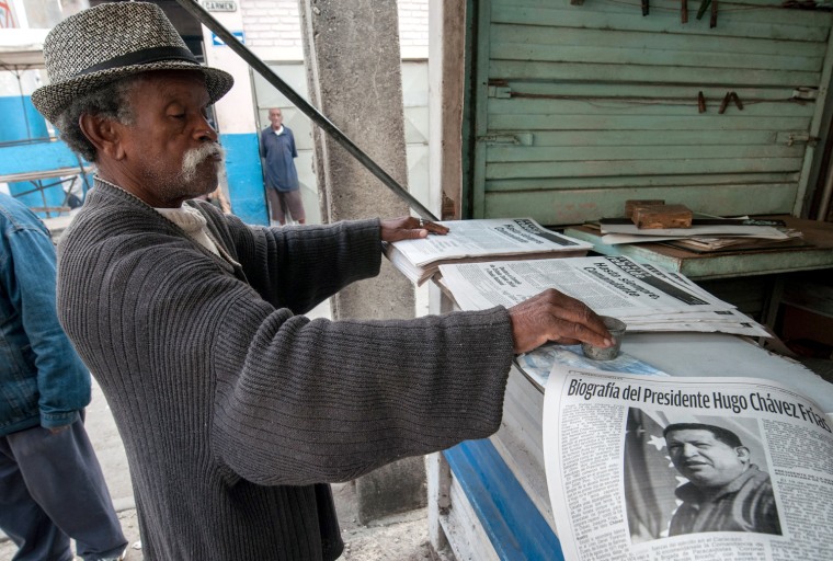 A Cuban reads a newspaper with articles about the late Venezuelan President Hugo Chavez, on March 6, 2013 in Havana.