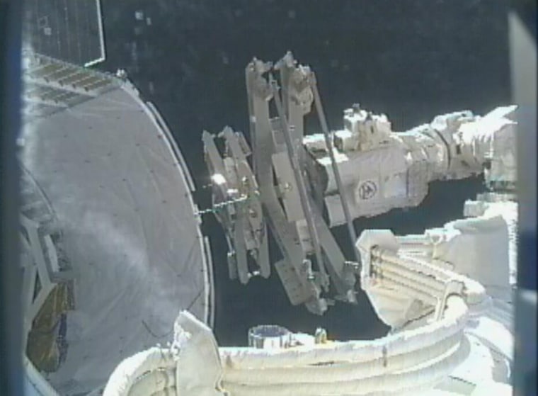 The International Space Station's robotic arm unloads grapple-bar assemblies from the unpressurized