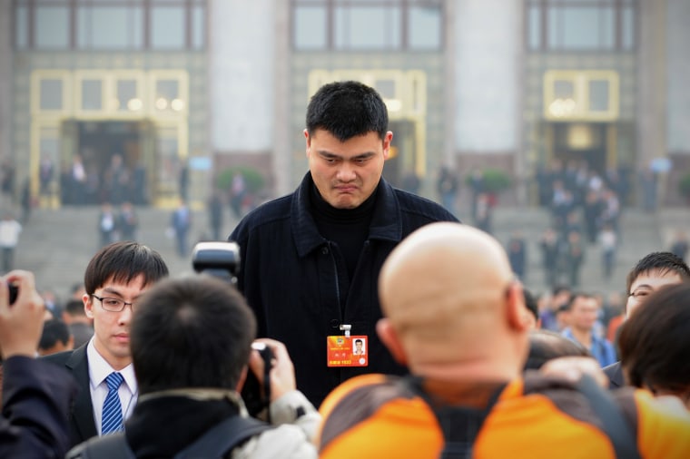 Chinese professional basketball player Yao Ming is surrounded by jounalists as he leaves the Great Hall of the People after the second plenary meeting of the first session of the 12th CPPCC National Committee in Beijing on March 7, 2013.