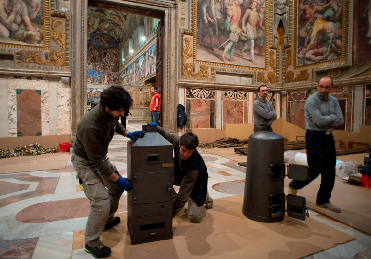 Workers prepare stoves in the Sistine Chapel that will be used to burn ballots during the conclave, in a photo released on Thursday.