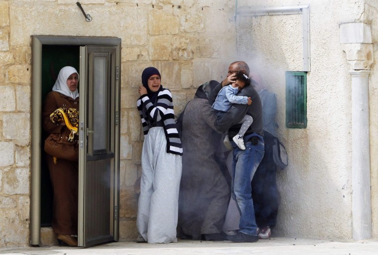 Palestinians react to tear gas fired by Israeli police during clashes after Friday prayers at a compound known to Muslims as al-Haram al-Sharif and to Jews as Temple Mount, in Jerusalem's Old City on March 8, 2013.