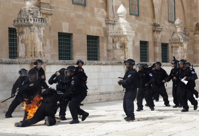An Israeli police officer falls, engulfed in flames after Palestinian protesters threw firebombs during clashes in Jerusalem's Old City on March 8, 2013.
