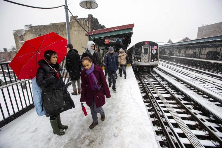 Commuters wait in heavy snow flurries to catch the subway into Manhattan in New York, on March 8.