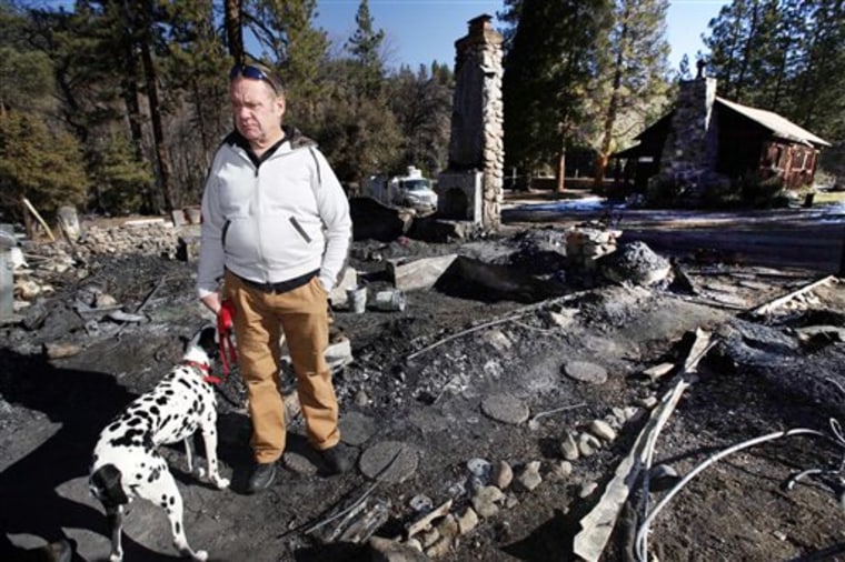 Rick Heltebrake, with his dog Suni, on Feb. 15 looks over the burned-out cabin where Christopher Dorner's remains were found near Big Bear, Calif. Dorner stole his pickup during his escape attempt. Heltebrake, a ranger who takes care of a Boy Scout camp, said he was checking the perimeter of the camp when he saw Dorner emerge from behind some trees.