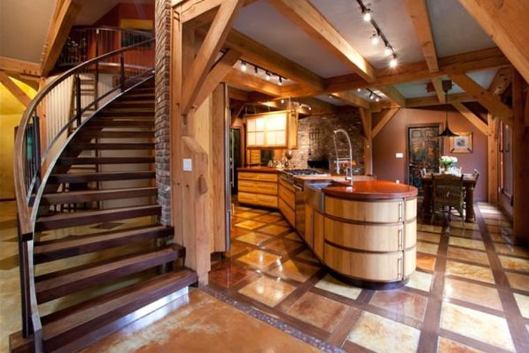 A handmade copper patina table dominates the kitchen, and the floors are made of wood and concrete.